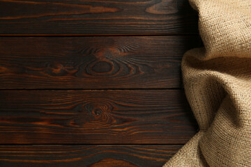 Burlap fabric on wooden table, top view. Space for text