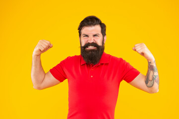angry guy with beard and hairstyle on yellow background, success
