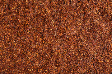 Heap of dry rooibos tea leaves as background, top view