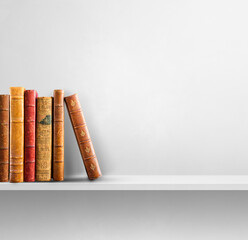 Row of old books on white shelf. Square background
