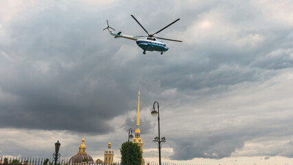 Passenger helicopter Mi-8 flies in the sky above the cathedrals of the city of St. Petersburg,...