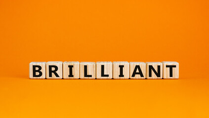 Brilliant symbol. The concept word Brilliant on wooden cubes. Beautiful orange table, orange background. Business and brilliant concept. Copy space.