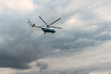Passenger helicopter Mi-8 flies in the cloudy summer sky. St. Petersburg. Russia