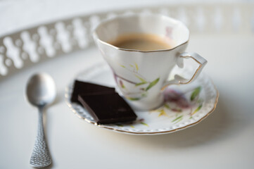Stylish cup of espresso black coffee with black chocolate on beautiful white tray