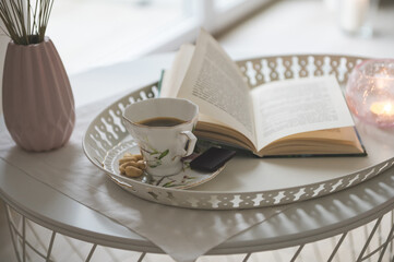Photo of stylish white tray with black koffee and dark chocoltte and a book