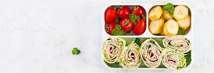 School lunchbox. Healthy lunch box with tortilla wraps, tomatoes and banana. Top view, flat lay