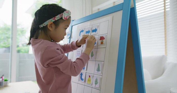 Little cute girl happy play and learn offline class computer language on board game Unplugged Coding computing concept for asia people kindergarten gen Z smart kids at home. STEM STEAM ICT skill.