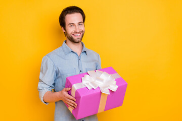 Photo of young handsome man happy positive smile hold present box party valentine day isolated over yellow color background