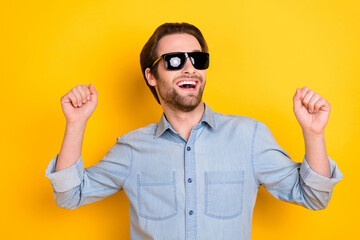 Photo of young excited man happy positive smile have fun dance party isolated over yellow color background