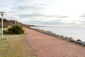 Walking sandy path along the seashore. An empty sea embankment on an autumn day