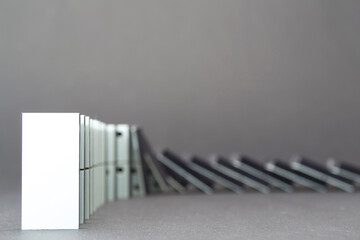 Dominoes falling in a row , gray background