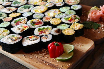 Sushi Set - Different Types of Maki Sushi and Nigiri Sushi. Served on dark wooden table.