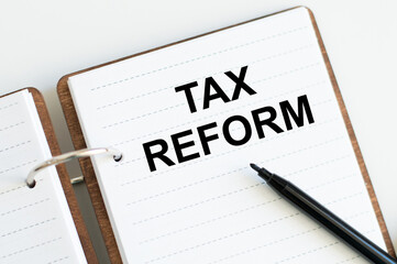 Notepad with text TAX REFORM with black marker on white background