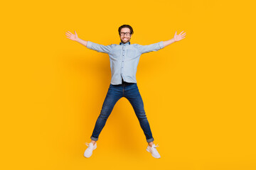 Fototapeta na wymiar Full length photo of young cheerful man happy positive smile active jump up isolated over yellow color background