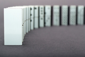 Dominoes falling in a row , gray background