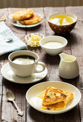 Breakfast of cheesecakes, coffee and tea. Cheesecakes of an unusual triangular shape.
