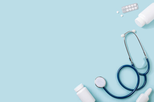 Medical concept, flat lay on blue background. Copy space. Stethoscope, pills, nasal spray and other medical equipment on blue, top view - Powered by Adobe