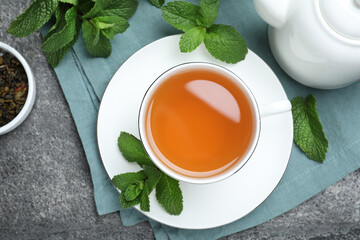 Cup of hot aromatic mint tea on grey table, flat lay