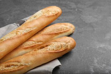 Tasty baguettes on grey table, closeup. Space for text