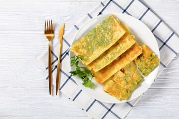 burritos with cheese and greens filings on a plate