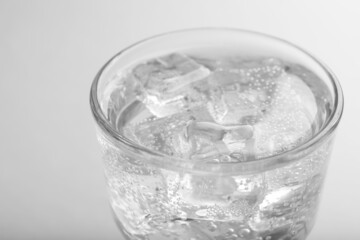 Glass of soda water with ice on white background, closeup
