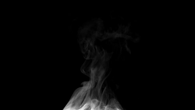 White steam spins and rises from the pan. White smoke rises from a large pot, which is located behind the frame. Isolated seamless loop black background.