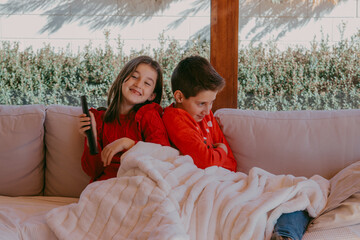 NIÑOS VIENDO LA TELEVISIÓN CON JERSEY NAVIDEÑO 