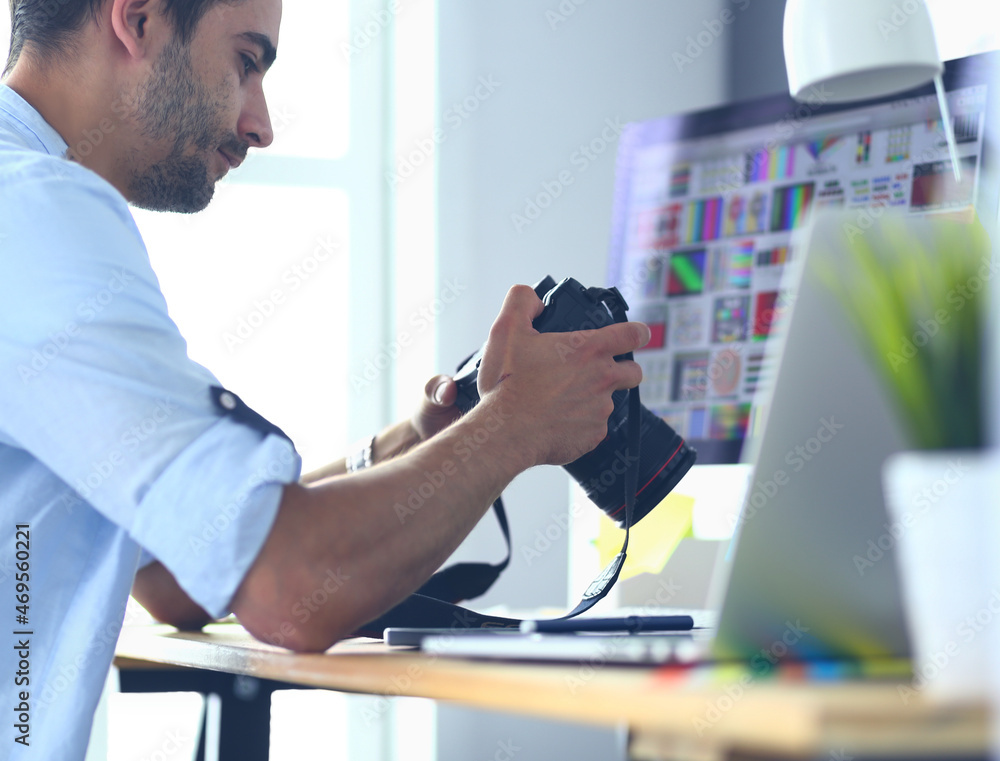 Poster portrait of young designer sitting at graphic studio in front of laptop and computer while working o
