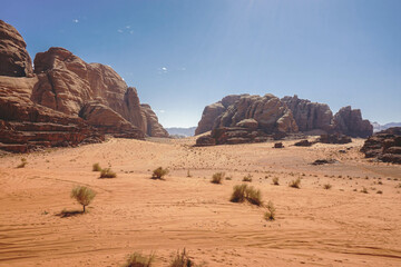 Fototapeta na wymiar deserted valley in the Wadi Rum desert, car tire tracks in the sand, nature of Jordan