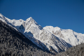 Snowy Mountains peaks and clear blue sky