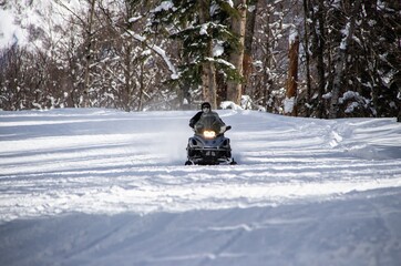 black snowmobile rides on a snowy road in the Caucasus mountains