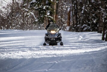 black snowmobile rides on a snowy road in the Caucasus mountains