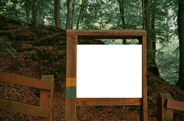 Wooden-framed old poster in the woods. Mock-up of forest guidepost. Environment friendly advertisement banner.