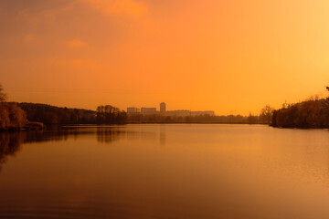 Orange sky after sunset on the lake. Wide lake in the evening after sunset