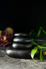 Stack of black zen stones on dark background