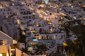  Illuminated whitewashed houses with terraces and pools and a beautiful view in Imerovigli on Santorini island, Greece