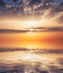 Fototapeta na wymiar Sun rays at dawn through the clouds over the sea.