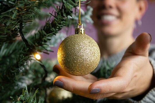 Chica Sonriente Decorando Arbol De Navidad Con Bola Dorada