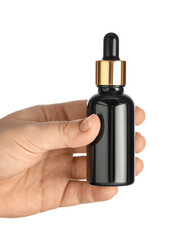 Woman holding dark bottle of essential oil on white background, closeup