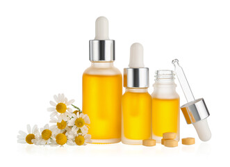 Different bottles of essential oil and chamomile flowers on white background