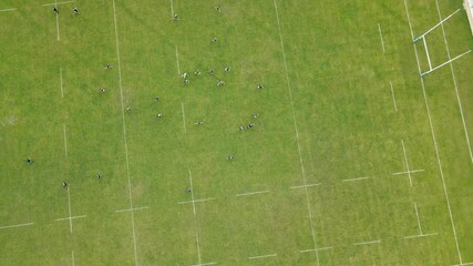 Aerial Top view of rugby game. Athletes training on a large green field. Sports competitions.
