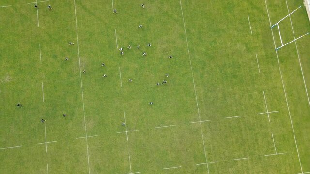 Aerial Top view of rugby game. Athletes training on a large green field. Sports competitions.