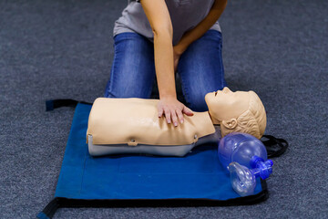 Demonstrating chest compressions. Medical doll is the simulator for training in first aid. Heart massage training. Concept of medical education and practice