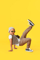 Cute dancing African-American boy on color background