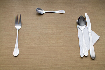 Set de cubiertos de metal sobre una mesa de madera.