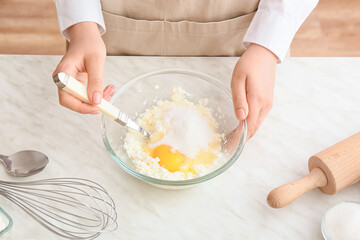 Woman cooking delicious dumplings on light background