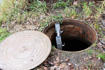 an open manhole of the city sewer and a ladder lowered into it