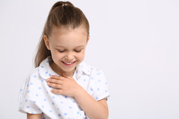 Portrait of flattered little girl on light background