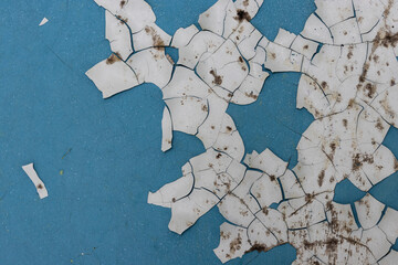 Peeling paint on the wall. Old concrete wall with cracked flaking paint. Weathered rough painted...
