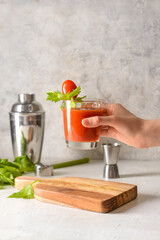 Woman with glass of bloody mary at table